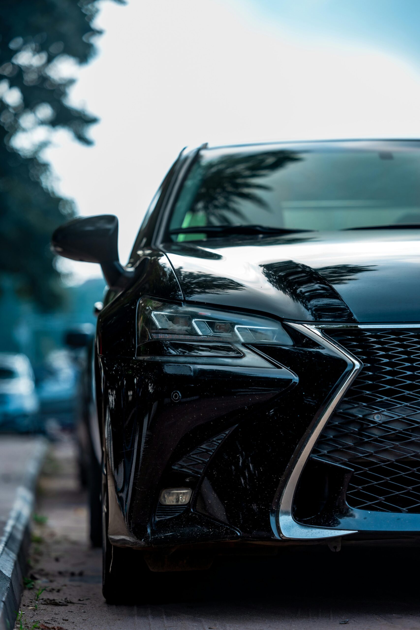 Front view of a sleek black luxury car parked on an outdoor street in Abuja, Nigeria.